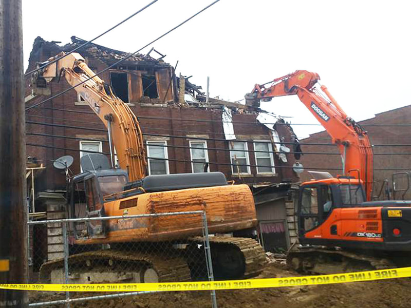 Apartment building being demolished with heavy equipment
